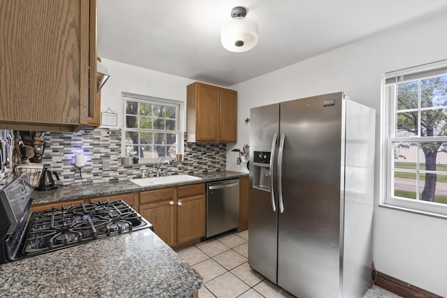 3106 Winifred St, Wayne, MI 48184 - kitchen with stainless steel appliances, a sink, decorative backsplash, brown cabinetry, and dark countertops