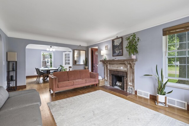 3106 Winifred St, Wayne, MI 48184 - living room featuring a ceiling fan, hardwood / wood-style flooring, a fireplace, arched walkways, and baseboards