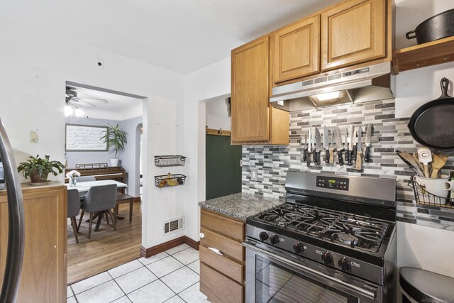 3106 Winifred St, Wayne, MI 48184 - kitchen with gas stove, under cabinet range hood, tasteful backsplash, light tile patterned flooring, and ceiling fan
