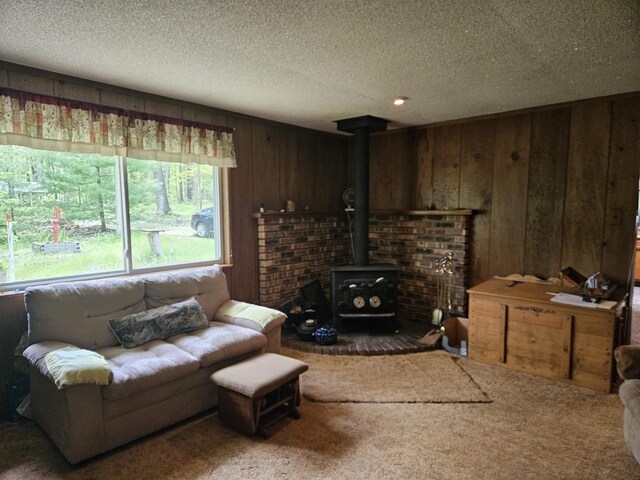 4949 Filter Rd, Harrison, MI 48625 - carpeted living area featuring a wood stove, wooden walls, and a textured ceiling