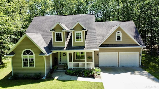 119 Mallard Ln, Gladstone, MI 49837 - view of front of house with covered porch, driveway, a front lawn, an attached garage, and a shingled roof