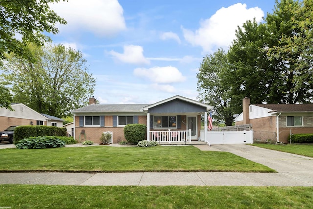 18053 Ellery Dr, Clinton Township, MI 48035 - view of front facade featuring brick siding, a gate, a porch, a chimney, and driveway