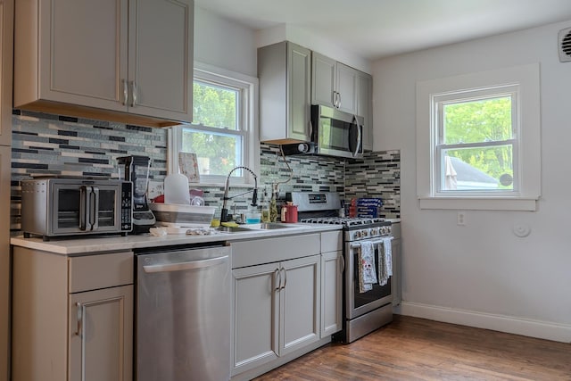 2129 N Clinton St, Saginaw, MI 48602 - kitchen featuring appliances with stainless steel finishes, a sink, gray cabinetry, and tasteful backsplash
