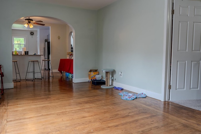 2129 N Clinton St, Saginaw, MI 48602 - empty room featuring arched walkways, a ceiling fan, wood finished floors, and baseboards