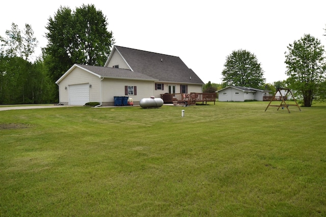 3850 Mando Ct, Coleman, MI 48611 - rear view of property with a lawn, a deck, an attached garage, a playground, and driveway