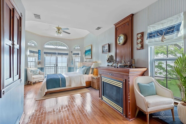 48816 Point Lakeview Dr, Chesterfield Twp, MI 48047 - bedroom featuring wallpapered walls, light wood-style floors, a baseboard radiator, and a fireplace