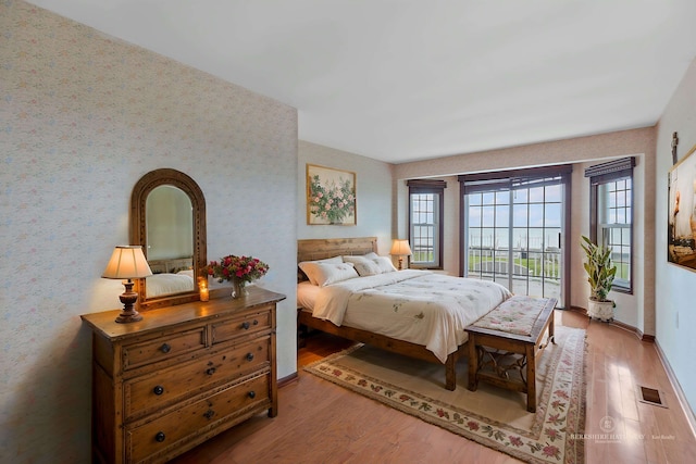 48816 Point Lakeview Dr, Chesterfield Twp, MI 48047 - bedroom with wallpapered walls, wood finished floors, access to exterior, and baseboards