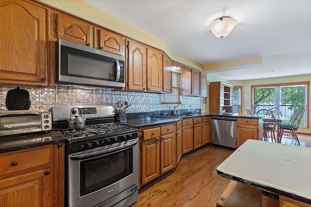 48816 Point Lakeview Dr, Chesterfield Twp, MI 48047 - kitchen with stainless steel appliances, wood finished floors, brown cabinets, tasteful backsplash, and a sink