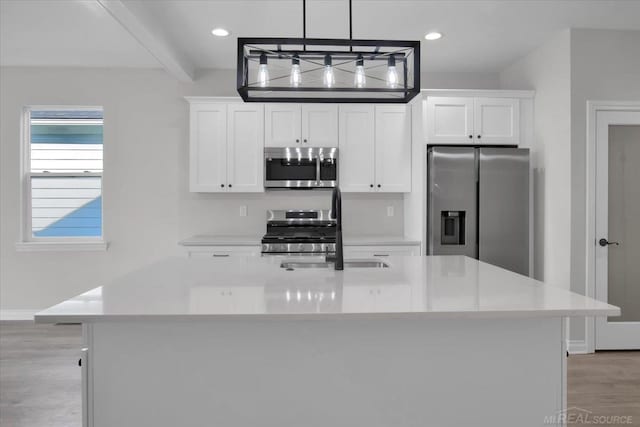 27621 Maryjane Ln E, Chesterfield Twp, MI 48047 - kitchen with appliances with stainless steel finishes, light wood finished floors, a kitchen island with sink, white cabinetry, and baseboards
