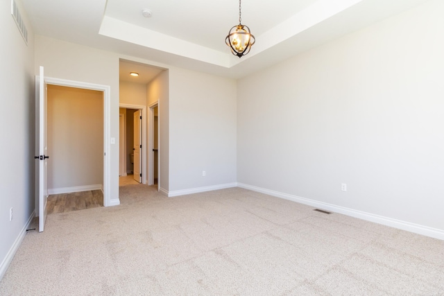 27633 Maryjane Ln E, Chesterfield Twp, MI 48047 - spare room with carpet, baseboards, a smoke detector, a tray ceiling, and a chandelier