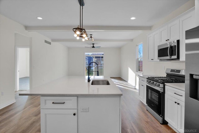 27645 Maryjane Ln E, Chesterfield Twp, MI 48047 - kitchen with stainless steel appliances, a sink, beamed ceiling, wood finished floors, and light countertops