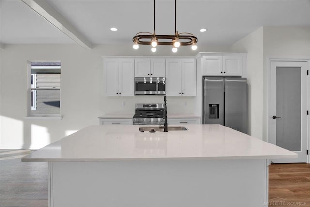 27645 Maryjane Ln E, Chesterfield Twp, MI 48047 - kitchen featuring stainless steel appliances, wood finished floors, white cabinetry, an island with sink, and recessed lighting