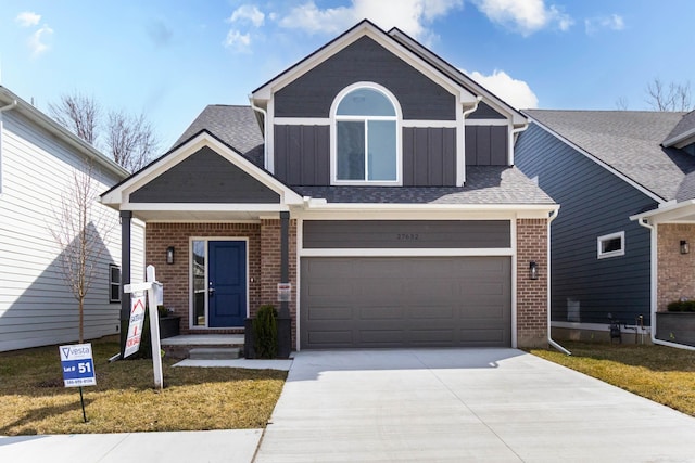 27632 Maryjane Ln E, Chesterfield Twp, MI 48047 - view of front facade with board and batten siding, driveway, brick siding, an attached garage, and a front yard