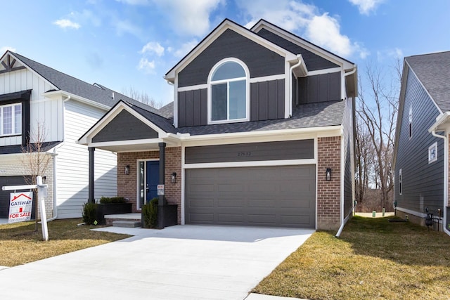 27632 Maryjane Ln E, Chesterfield Twp, MI 48047 - view of front facade featuring board and batten siding, driveway, a front yard, an attached garage, and brick siding