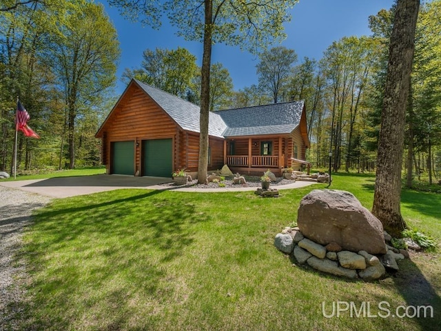 E1849 H44 Hwy, Trenary, MI 49891 - log cabin with a porch, log siding, concrete driveway, and a front lawn