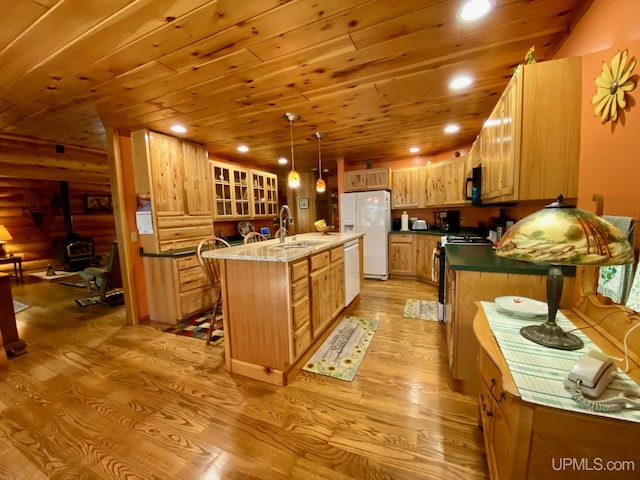 E1849 H44 Hwy, Trenary, MI 49891 - kitchen featuring white appliances, light wood-style floors, a wood stove, a sink, and wood ceiling