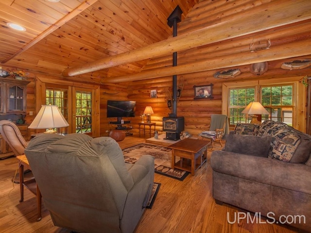 E1849 H44 Hwy, Trenary, MI 49891 - living area with a wood stove, light wood finished floors, healthy amount of natural light, and log walls