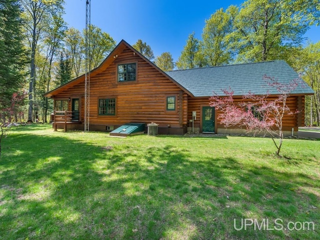 E1849 H44 Hwy, Trenary, MI 49891 - rear view of house with log siding, a lawn, and central AC unit