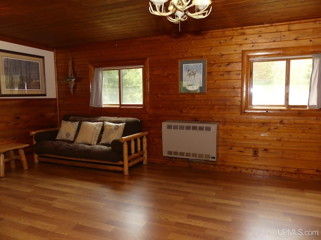 22252 E Webb Rd, Grand Marais, MI 49839 - living area with a chandelier, wood ceiling, heating unit, wood walls, and wood finished floors