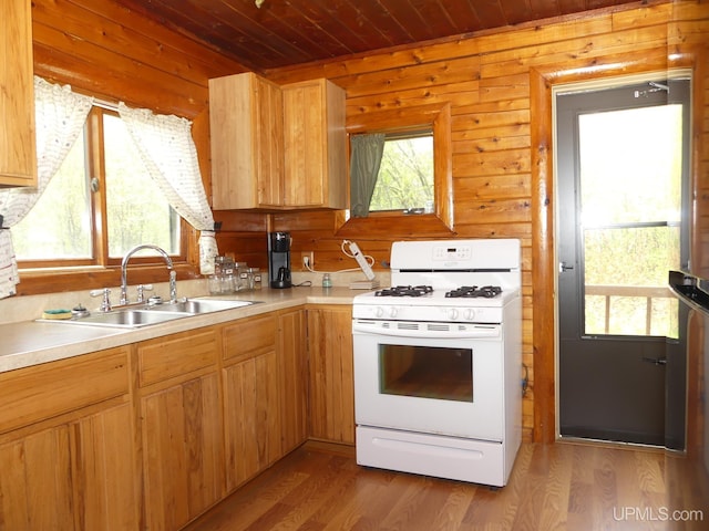 22252 E Webb Rd, Grand Marais, MI 49839 - kitchen with white range with gas cooktop, wooden ceiling, light wood-style floors, light countertops, and wood walls