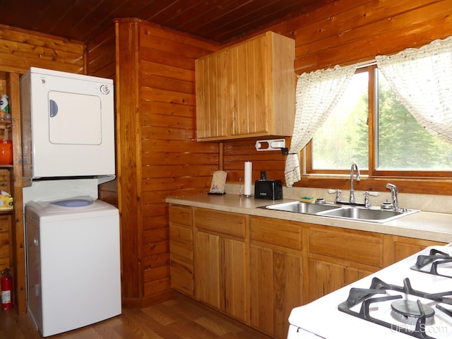 22252 E Webb Rd, Grand Marais, MI 49839 - kitchen featuring stacked washer / dryer, wood ceiling, wood walls, light countertops, and white gas range