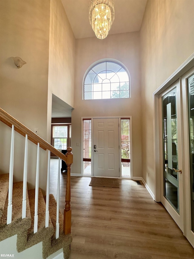 39148 Canterbury Dr, Harrison Twp, MI 48045 - foyer entrance featuring wood finished floors, a chandelier, a high ceiling, baseboards, and stairs