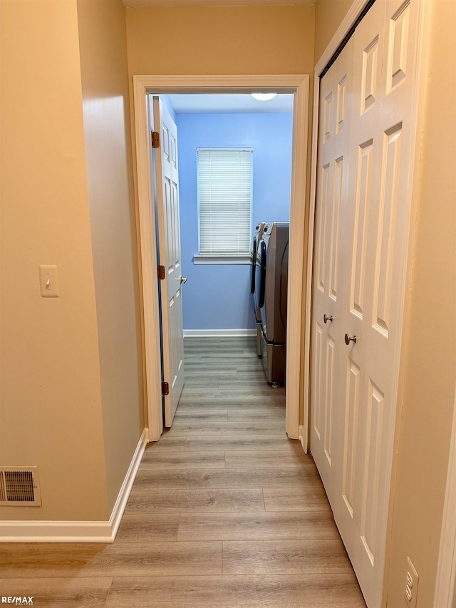 39148 Canterbury Dr, Harrison Twp, MI 48045 - corridor with washer and clothes dryer, baseboards, and light wood-style flooring