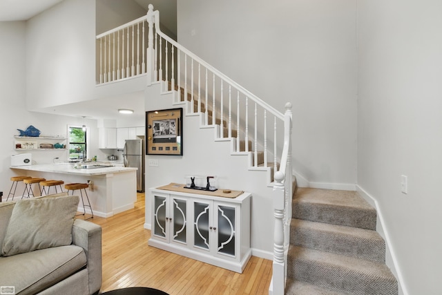 3620 Lakeshore Dr, Lapeer, MI 48446 - stairs featuring wood finished floors, a high ceiling, and baseboards