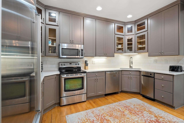 624 E G St, Iron Mountain, MI 49801 - kitchen with appliances with stainless steel finishes, a sink, gray cabinets, backsplash, and light countertops