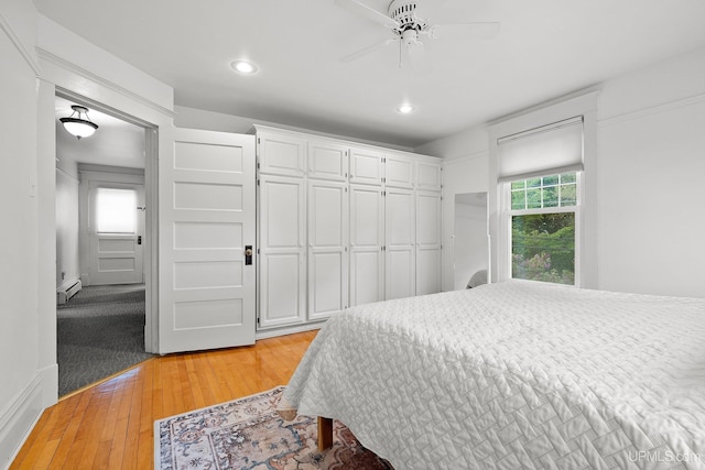 624 E G St, Iron Mountain, MI 49801 - bedroom with baseboard heating, light wood-style floors, recessed lighting, and a closet