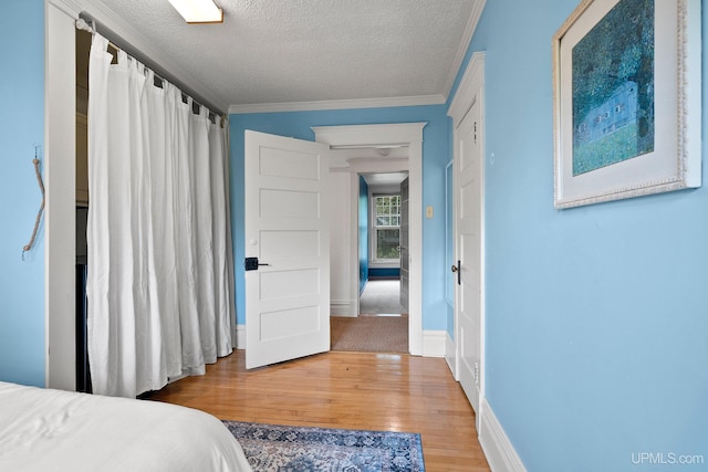 624 E G St, Iron Mountain, MI 49801 - bedroom featuring wood finished floors, a textured ceiling, ornamental molding, and baseboards