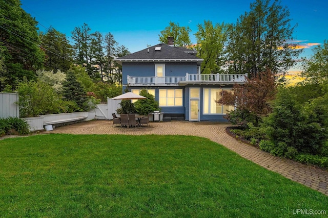 624 E G St, Iron Mountain, MI 49801 - rear view of house featuring a balcony, a patio, and a chimney