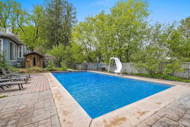 624 E G St, Iron Mountain, MI 49801 - view of pool featuring a water slide, a fenced backyard, a patio area, and view of scattered trees