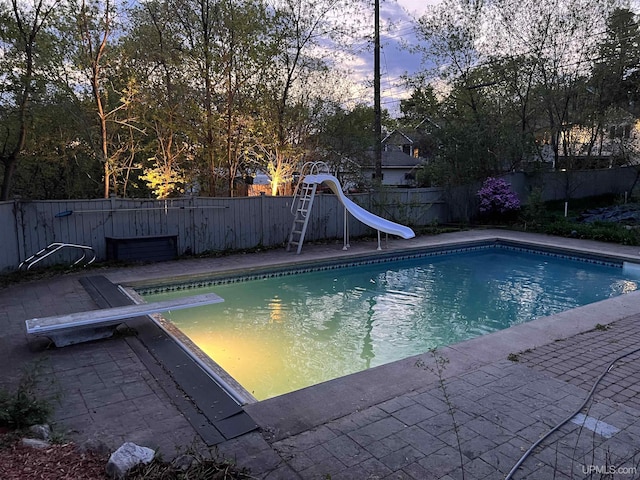 624 E G St, Iron Mountain, MI 49801 - view of swimming pool with a diving board, a water slide, and a fenced backyard