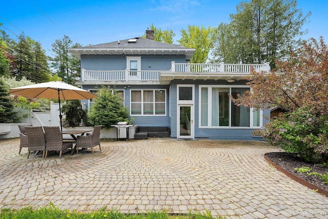 624 E G St, Iron Mountain, MI 49801 - rear view of house featuring a balcony, a patio, a chimney, and outdoor dining space