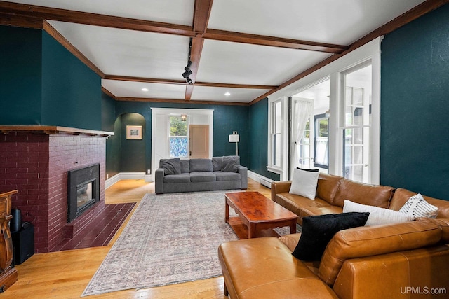 624 E G St, Iron Mountain, MI 49801 - living area featuring light wood-type flooring, arched walkways, a brick fireplace, baseboards, and beam ceiling