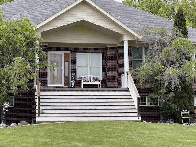815 Cove Rd, Wales, MI 48027 - view of front of home with brick siding, a porch, a front yard, and a shingled roof