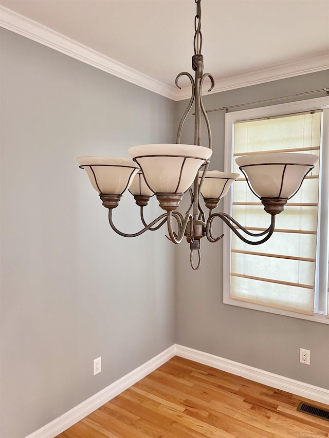815 Cove Rd, Wales, MI 48027 - detailed view of baseboards, crown molding, wood finished floors, and a chandelier