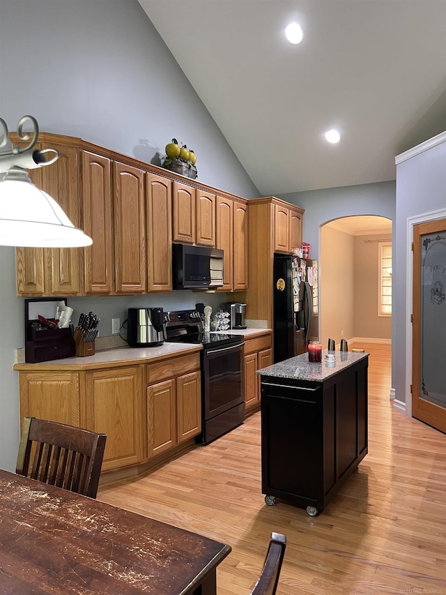 815 Cove Rd, Wales, MI 48027 - kitchen with black appliances, arched walkways, light wood-style floors, a center island, and recessed lighting