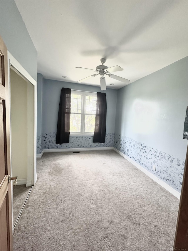 815 Cove Rd, Wales, MI 48027 - spare room featuring carpet flooring, ceiling fan, baseboards, and wallpapered walls