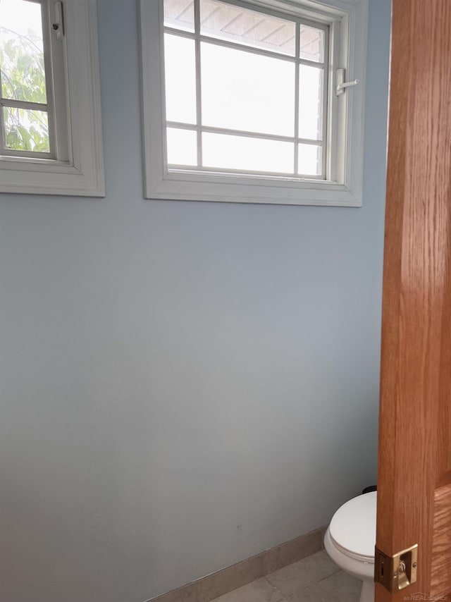 815 Cove Rd, Wales, MI 48027 - bathroom with healthy amount of natural light, toilet, baseboards, and tile patterned floors