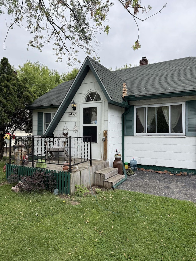 1471 James St, Burton, MI 48529 - view of front of house featuring a chimney, roof with shingles, and a front yard