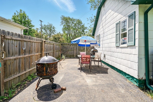 1471 James St, Burton, MI 48529 - fenced backyard with outdoor dining space, a patio area, and a fire pit