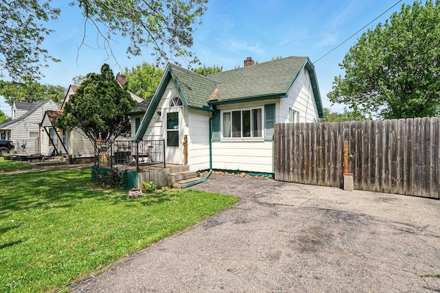 1471 James St, Burton, MI 48529 - view of front of house with a shingled roof and a chimney