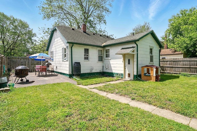 1471 James St, Burton, MI 48529 - rear view of house with a patio, a chimney, and roof with shingles