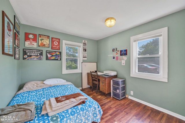 622 Kendon Dr, Lansing, MI 48910 - bedroom with multiple windows, wood finished floors, and baseboards