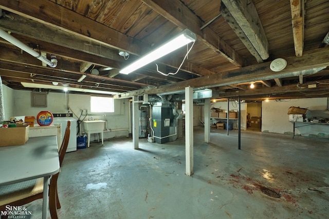 622 Kendon Dr, Lansing, MI 48910 - below grade area with washer and clothes dryer, heating unit, a sink, and water heater