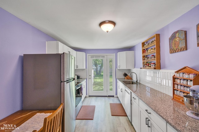 622 Kendon Dr, Lansing, MI 48910 - kitchen with a sink, stainless steel appliances, decorative backsplash, and white cabinetry