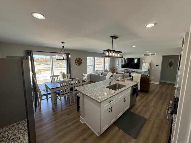 34317 Pratt Rd, Memphis, MI 48041 - kitchen with stainless steel appliances, a sink, open floor plan, a chandelier, and white cabinets