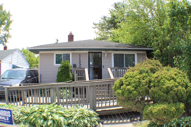 11330 Packard Ave, Warren, MI 48089 - rear view of house featuring a chimney and a wooden deck